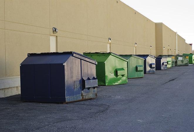 a group of dumpsters lined up along the street ready for use in a large-scale construction project in Franksville